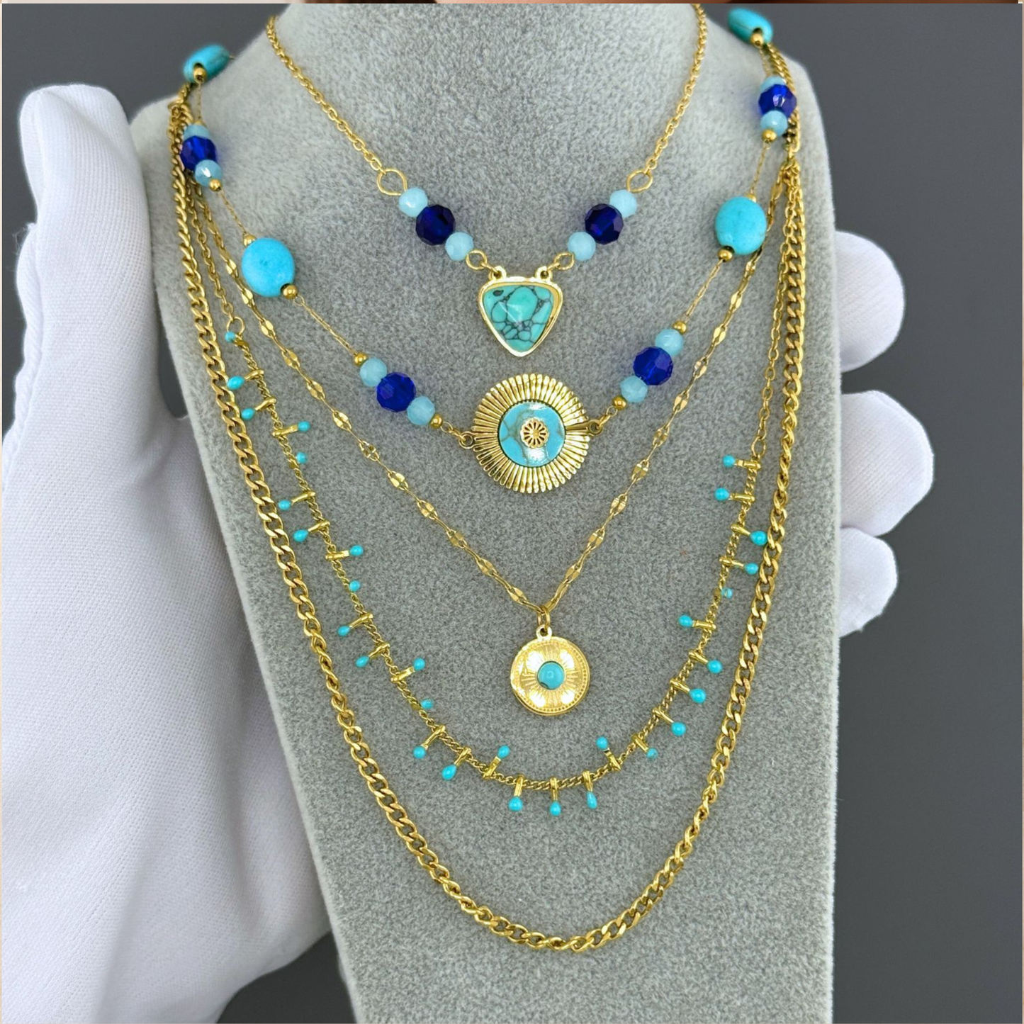 Collar doble en dorado con cuentas y charms turquesa y azul. En stainless steel y gold plating.
