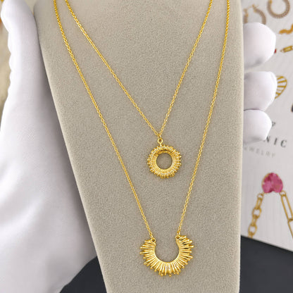 Un collar doble con diseño inspirado en el brillo del sol en dorado y stainless steel