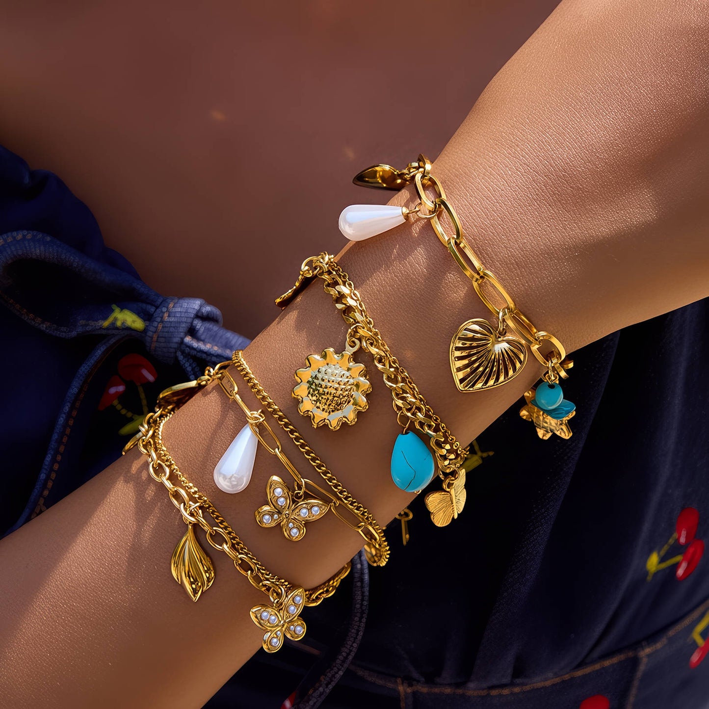 Pulsera dorada con charms variados y detalles de color
