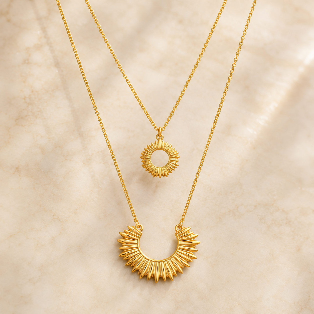 Un collar doble con diseño inspirado en el brillo del sol en dorado y stainless steel
