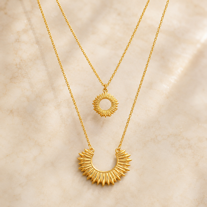 Un collar doble con diseño inspirado en el brillo del sol en dorado y stainless steel